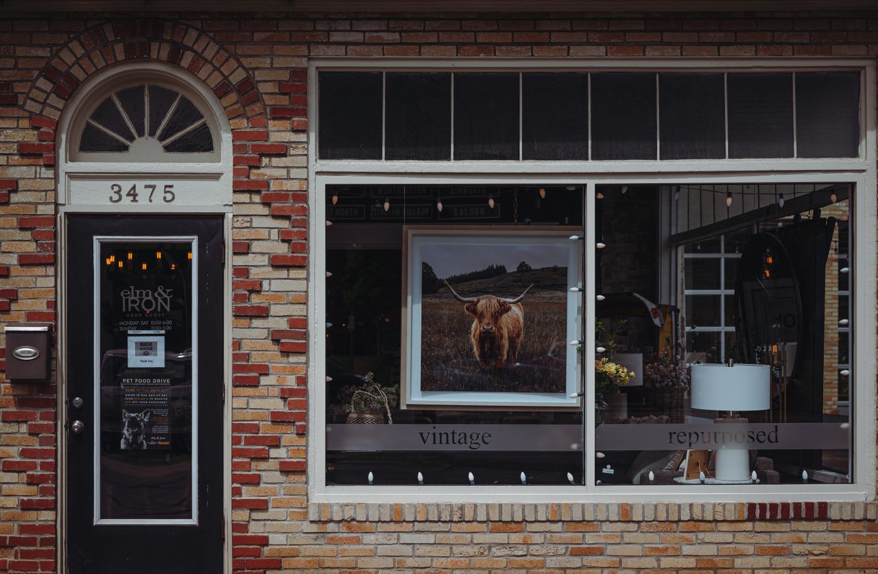 A picturesque vintage café storefront with a brick facade, featuring unique decor and signage.